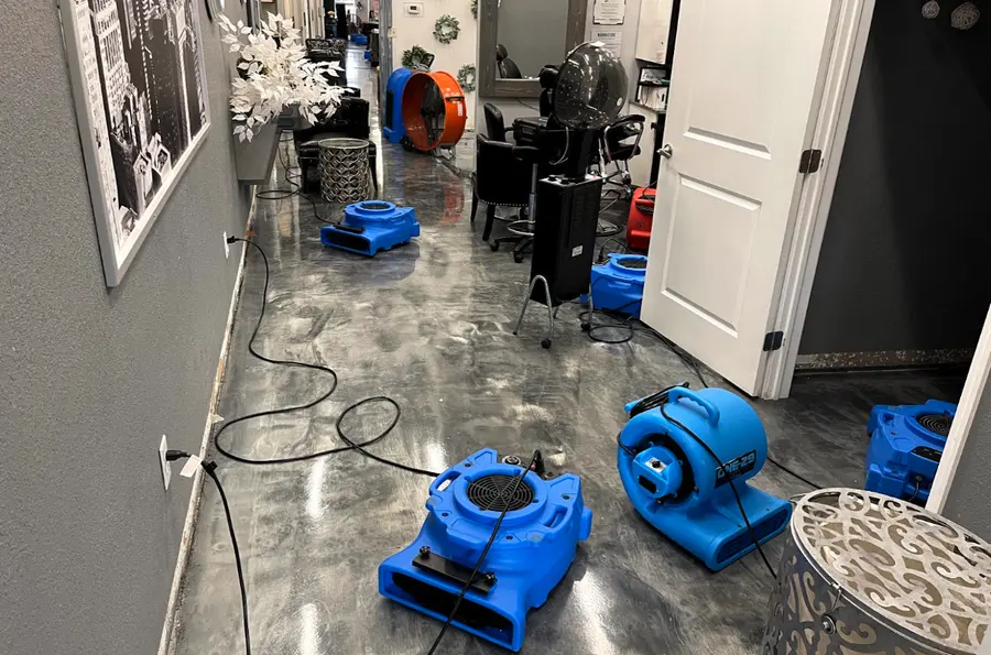 Blue air movers drying a hallway with a wet floor during a dry-out in Pueblo, CO