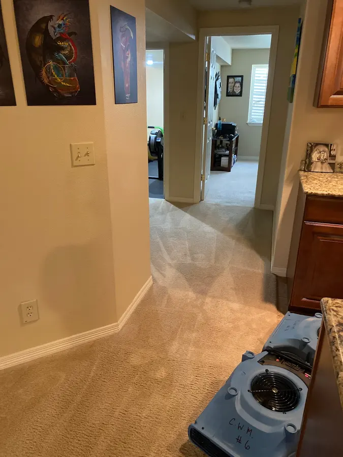 Air mover drying a hallway beside an open door during water damage cleanup in Cañon City, Colorado