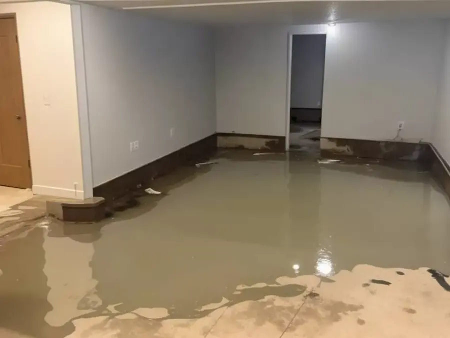 Standing water across the floor of a flooded basement room in Pueblo, CO