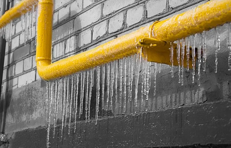 Icicles hanging from a pipe along a block wall after a hard freeze in Pueblo, CO
