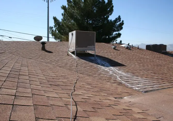 Rooftop swamp cooler with water streaking down the shingles below it in Pueblo, CO